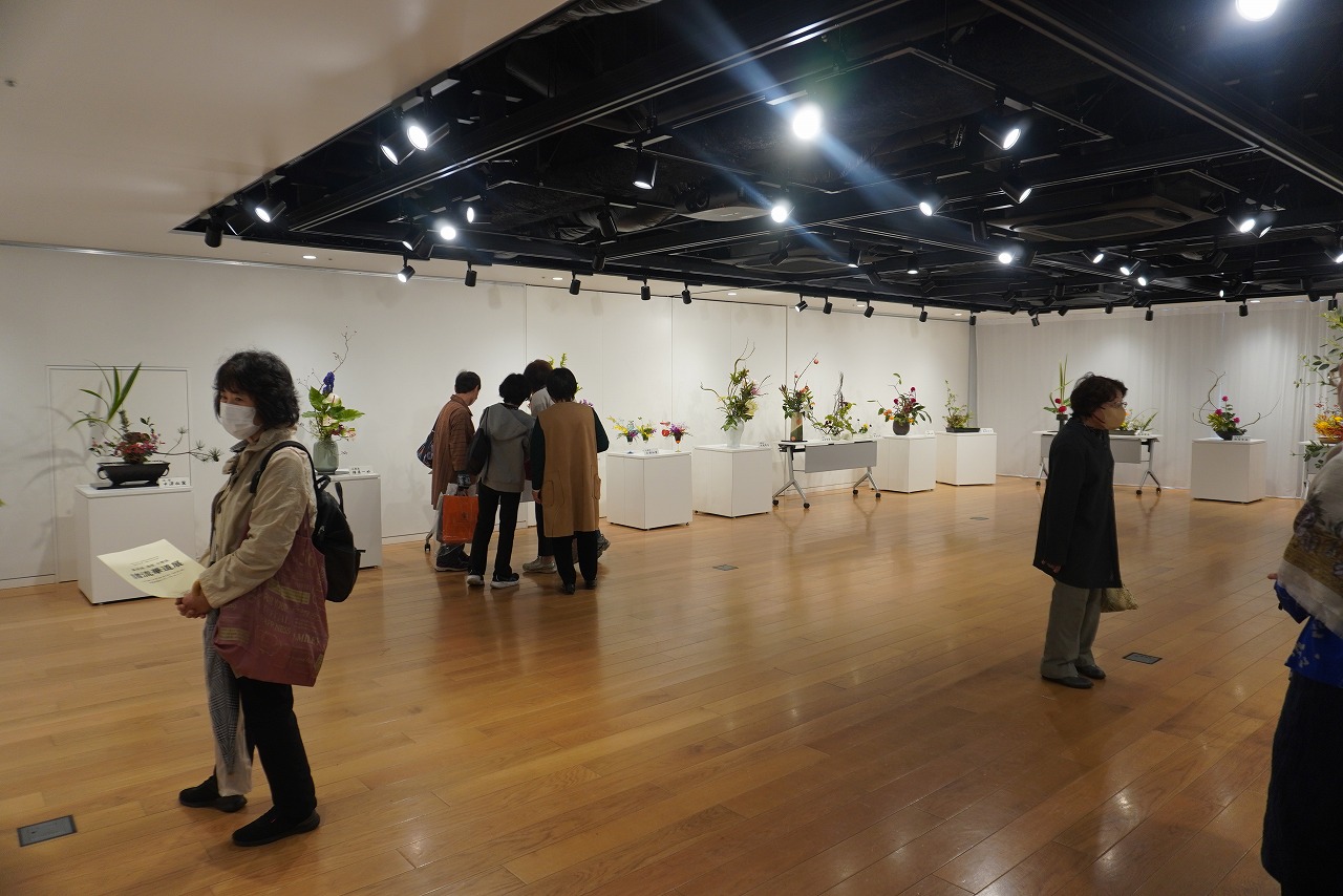 華道の花が並べられているなか10人程度の人が観覧している