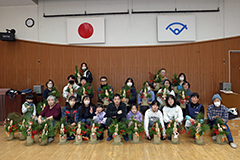 ミニサイズの門松を持った人々が集まり、前後に並んで写した、須賀川秋祭りの記念写真