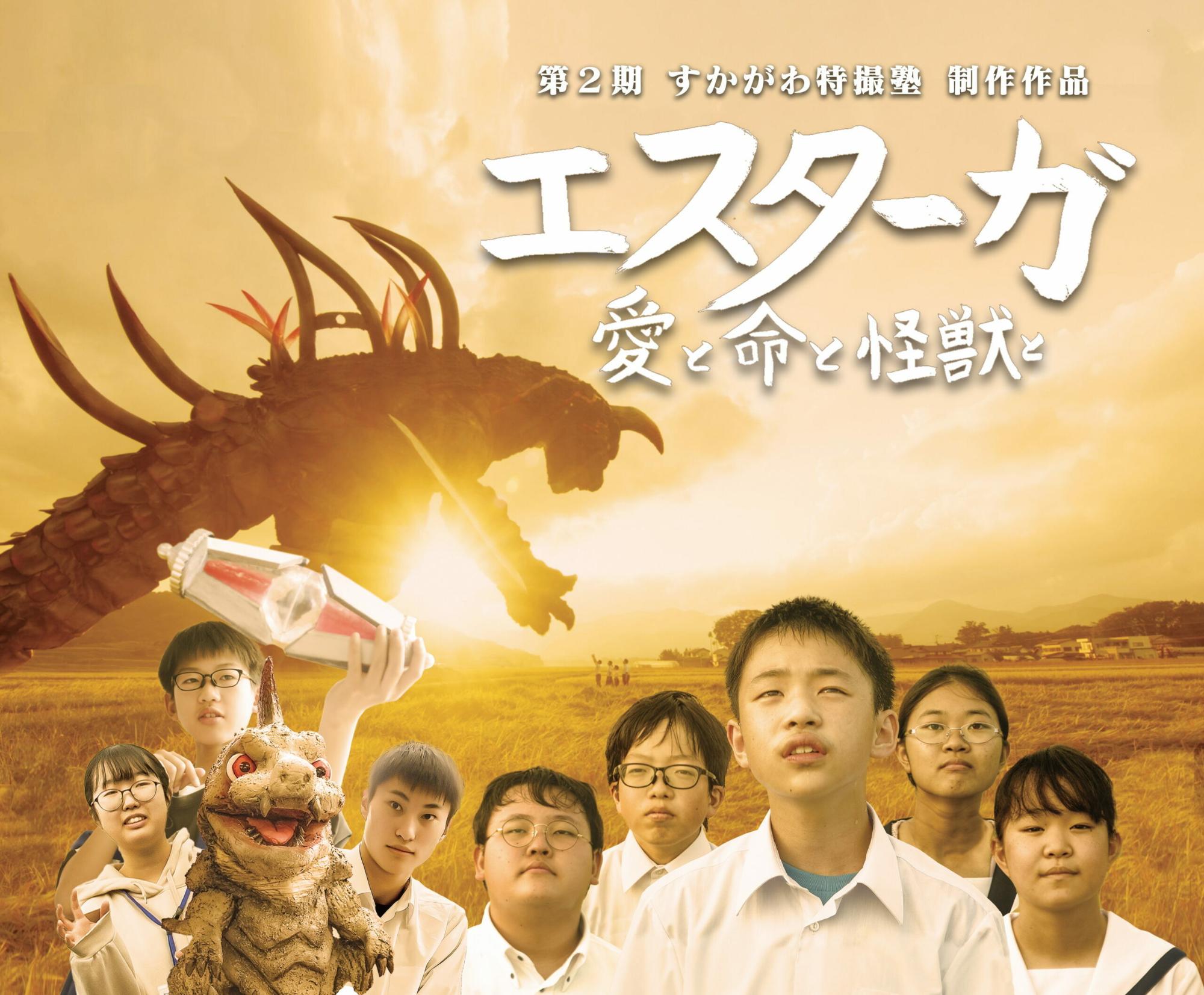 夕焼けの田園風景を背景に「エスターガ 愛と命と怪獣と」という題字が躍り、手前に並ぶ若者たちや小型怪獣、そして背後に巨大な怪獣のシルエットが黄金色の光に包まれて描かれた、第2期すかがわ特撮塾の制作ポスター写真