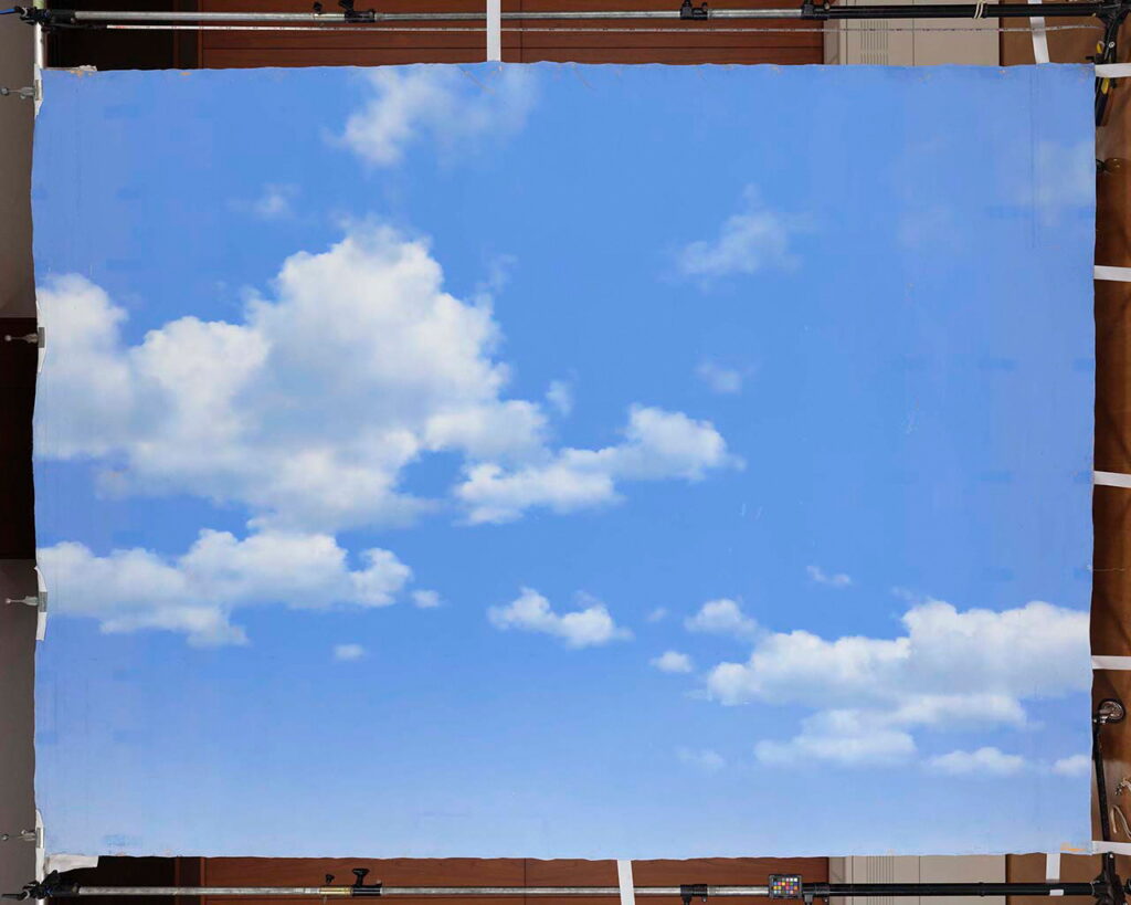 抜けるような明るい青空に、輪郭のくっきりとした白い積雲がバランスよく配置して描かれた大型背景画の写真