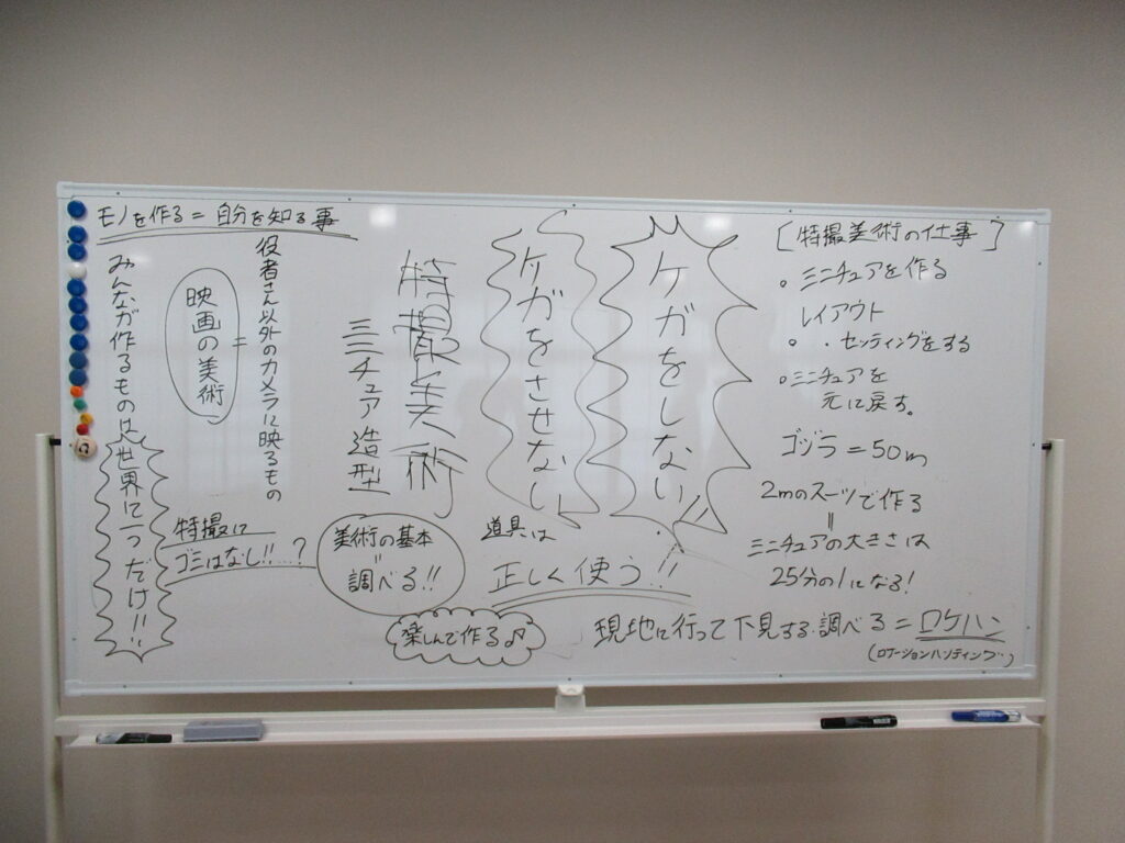 「特撮美術の仕事」や「ケガをしない」といった講義内容が黒や青のペンでびっしりと書き込まれたホワイトボードを写した写真