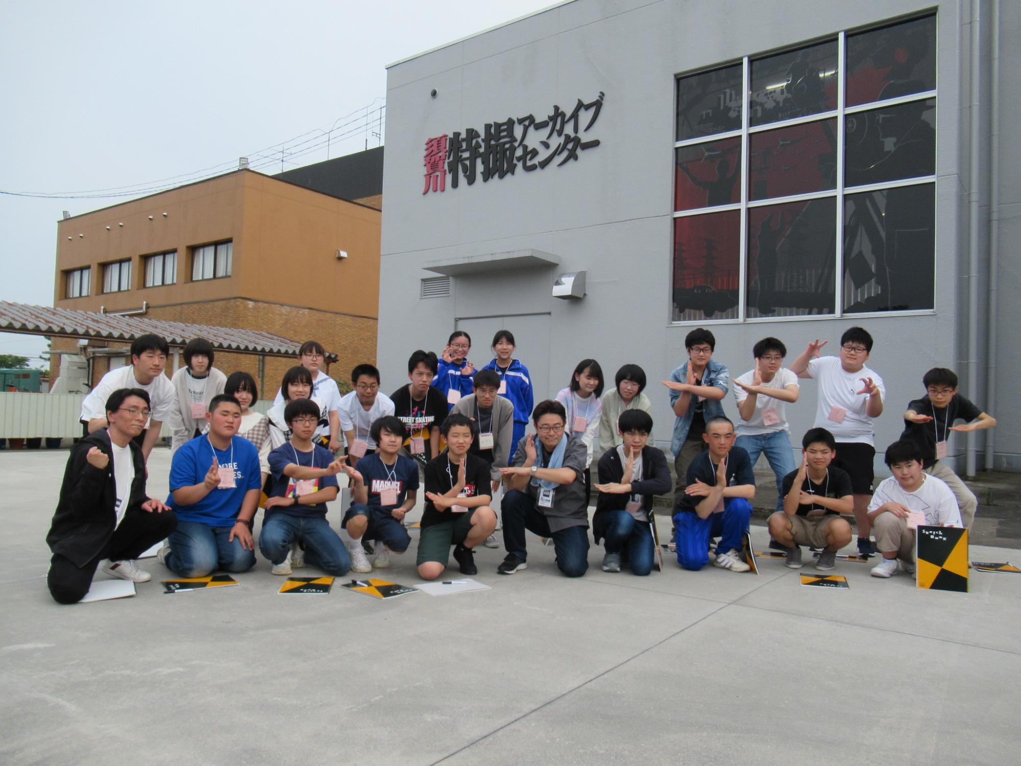 「須賀川特撮アーカイブセンター」という文字が掲げられた建物の前で、複数の塾生と講師が集まった集合写真