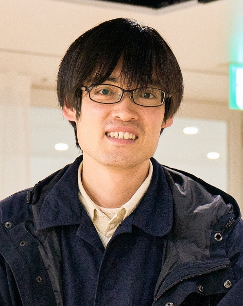 落ち着いた室内で濃色の上着とシャツを重ねて着ている正面に立ち穏やかな姿勢を保つ石井那王貴特撮美術講師の写真