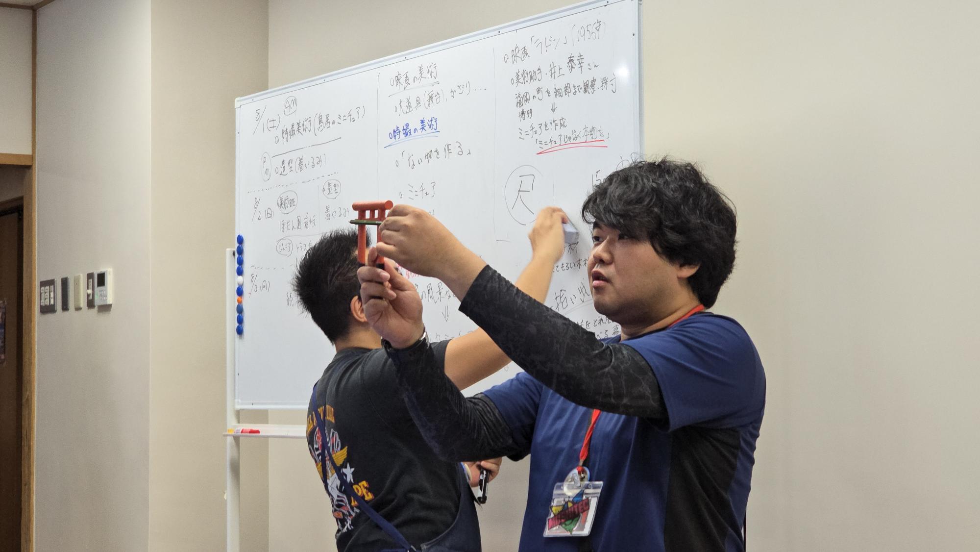 すかがわ特撮塾の活動で講師が特撮美術についてや鳥居のミニチュア制作について説明している様子
