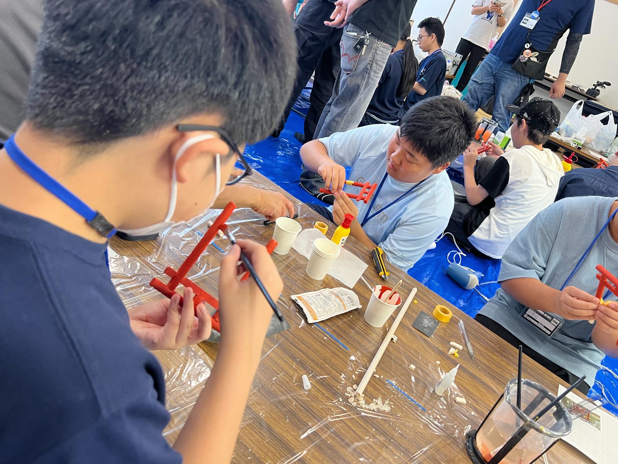 すかがわ特撮塾の活動で塾生が鳥居のミニチュアを制作し塗装している作業の様子