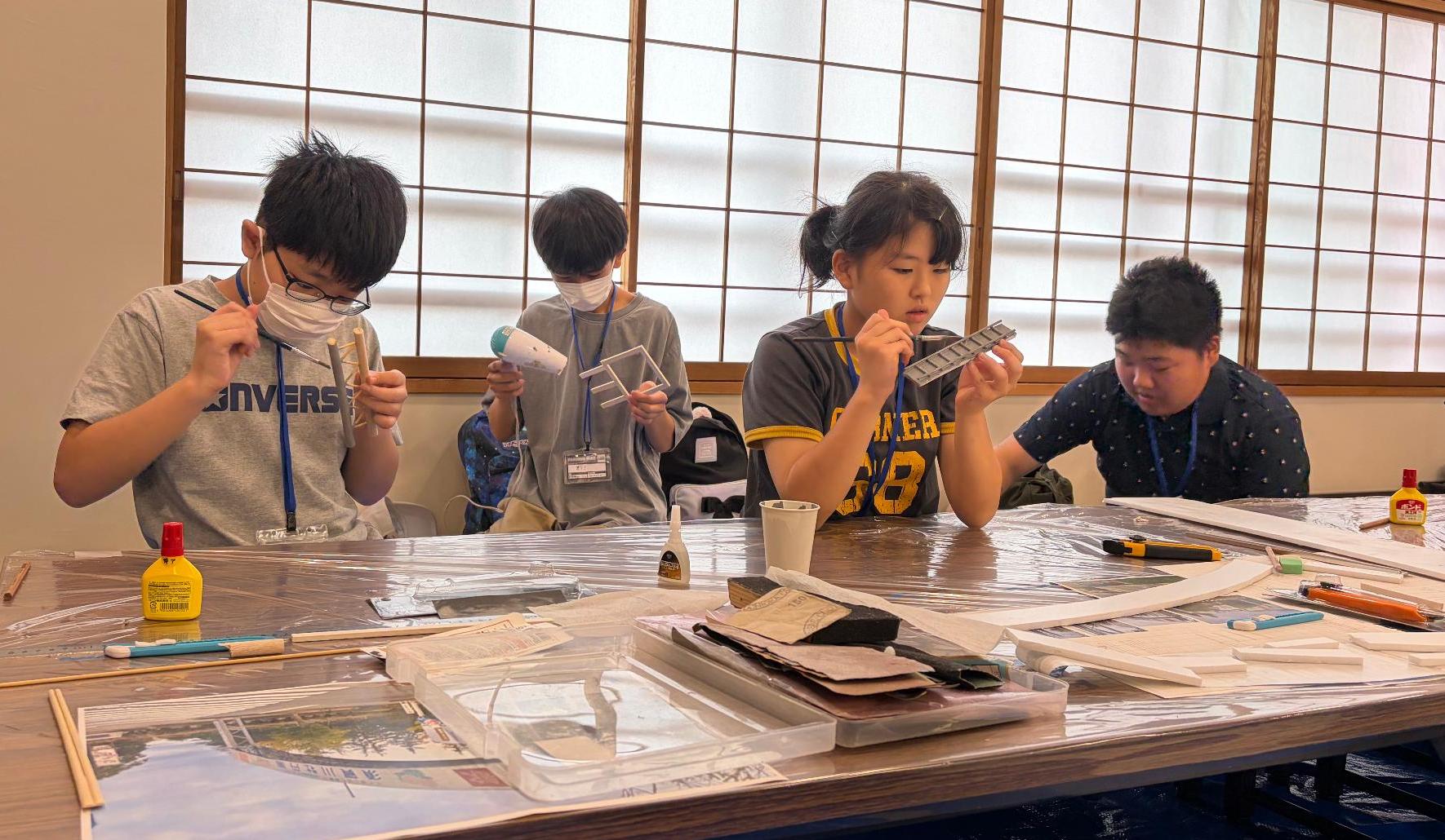すかがわ特撮塾の活動で塾生たちが舞台になる場所のミニチュアを制作している様子