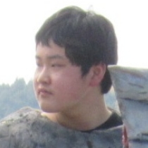 金属風の装甲衣装を着た男性が横向きに立ち肩口の造形を見せる姿を捉えた写真