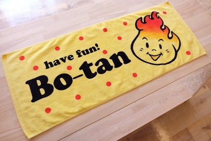 黄色の生地に赤い水玉模様と「have fun! Bo-tan」の黒い文字、ボータンの顔がプリントされたタオルの写真