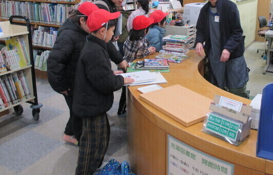 子ども達がカウンターでたくさんの本を借りている写真