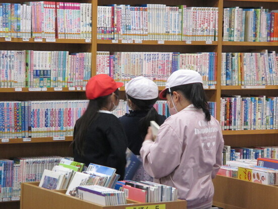 子どもたちが本棚を眺めたり選んだりしている写真