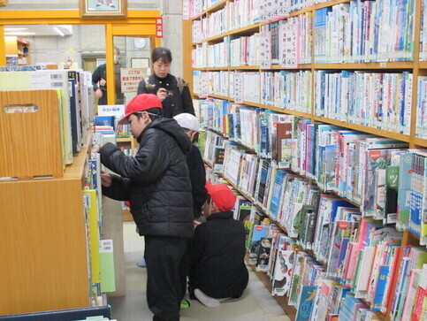 子どもたちが本棚を眺めたり選んだりしている写真
