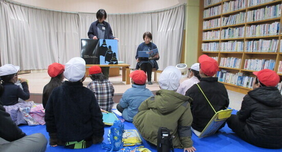 子ども達に絵本を読み聞かせしている写真