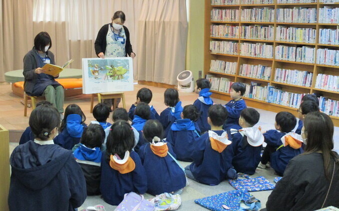 子どもたちに絵本の読み聞かせをしている写真