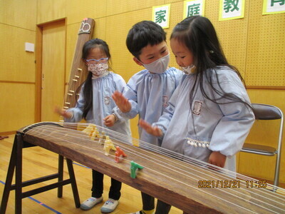 琴に触れ、弦をはじく子どもたち
