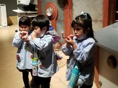 写真:ストローに乗せた小さい球を息で持ち上げる子ども
