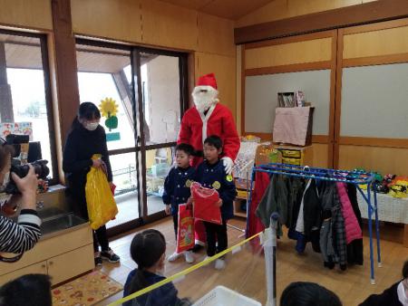 写真：サンタからプレゼントをもらう子どもたち