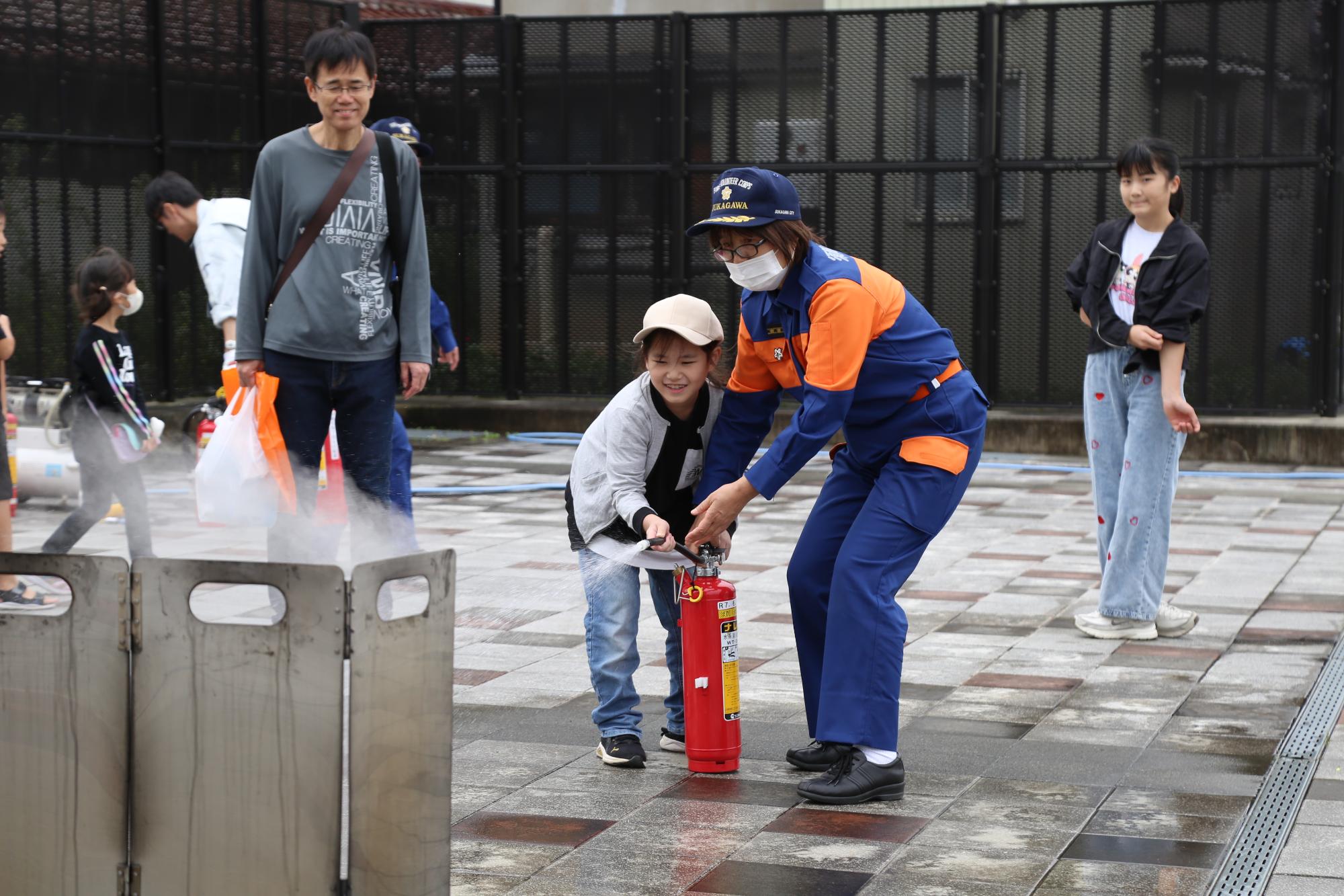 消火器使用の方法を教えてもらう様子