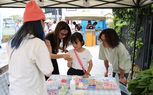 地域のマーケットイベントに参加する家族の様子