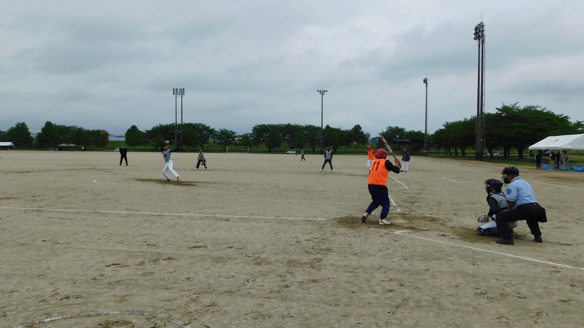 市民スポーツ広場で選手がソフトボールの試合を行っている写真