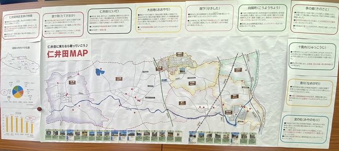 大きな模造紙の中央に仁井田地区全体の地図、周囲に各区の特徴が貼られた、掲示用マップ全体像の写真