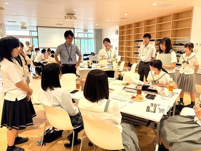 学生たちがテーブルを囲んで資料を広げつつ意見を交わし、協働的に活動している様子の写真