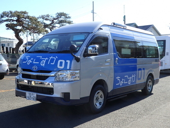 青とシルバーのツートンカラーの車両が舗装された駐車場に停まっており、側面には白い文字で「ちょこすか01」と大きく書かれているワゴンタイプの車の写真