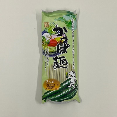 薄緑色のパッケージに「かっぱ麺」と大きく書かれ、きゅうりを担いだカッパのイラストや、盛り付けられた麺のイメージ、下部には新鮮なきゅうりの写真が配置されたかっぱ麺の商品の写真