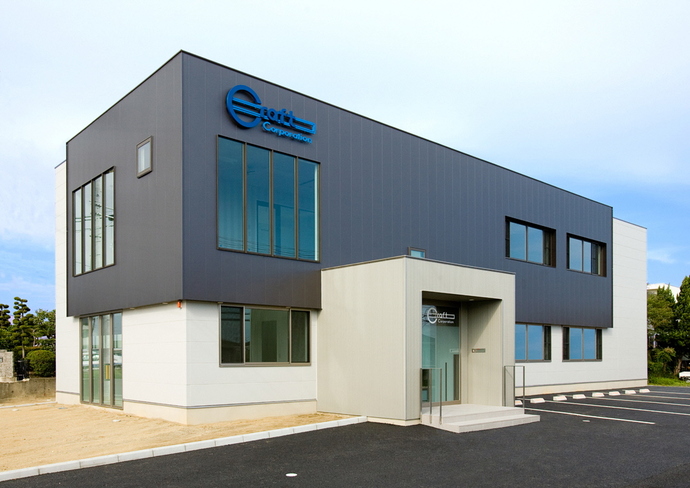 濃いグレーと白の配色の外壁がモダンな印象を与える二階建ての建物で、上部に青いロゴマークが設置された株式会社クラフトの外観写真