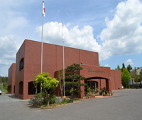 赤いユニフォームと白いズボンを着用したピッチャーが、ボールを握った右手を胸の高さまで引き上げ投球しようとしている瞬間の写真