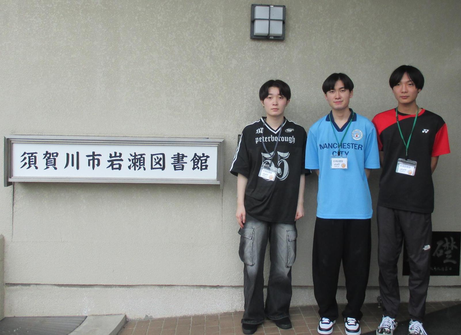 岩瀬図書館の看板の横に高校生が並んでいる写真