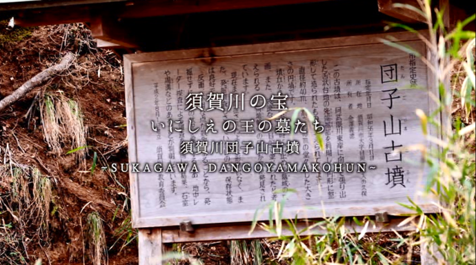 「須賀川の宝 いにしえの王の墓たち 須賀川団子山古墳 〜SUKAGAWA DANGOYAMAKOHUN〜」という紹介テキストが、団子山古墳の解説が書かれた木製の看板を正面から捉えた場面に重なっている写真