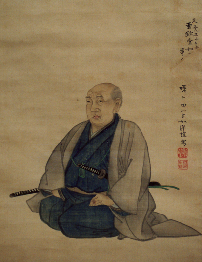 紺色の着物と薄いグレーの羽織を身にまとい、腰に刀を差して正座する亜欧堂田善の姿を描いた肖像画