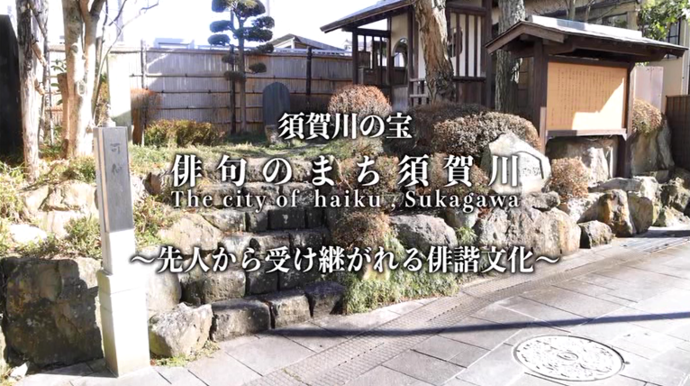 「須賀川の宝 俳句のまち須賀川 The city of haiku, Sukagawa 〜先人から受け継がれる俳諧文化〜」という白い縁取りテキストが、石積みの階段や案内板、手入れされた植栽がある和風の庭園のような風景に重なっている写真