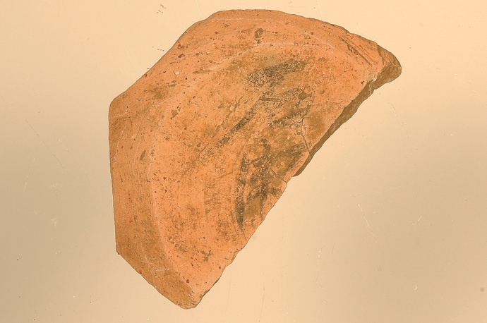 赤茶色の土器が置かれ、その湾曲した表面には当時の生活や文化を暗示するような黒っぽい模様や煤の跡が薄っすらと残っている、考古学的な資料となりうる出土品の画像