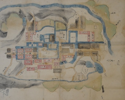 中央には区画分けされた町並みが広がり、水路や周囲をゆったりと流れる青い河川や山々、点在する池が描かれた、淡い色彩で描かれた絵図の画像