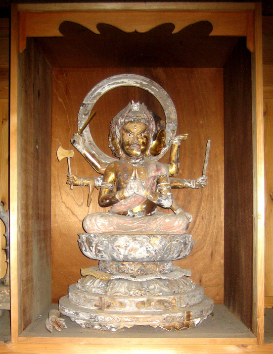 木製の厨子に安置された、憤怒の表情を浮かべ複数の腕で斧などの法具を持つ金色の仏像が、円形の光背を背負い蓮華座に結跏趺坐で鎮座している様子を捉えた、経年変化による塗装の剥落が見られる勢至堂馬頭観音像の写真