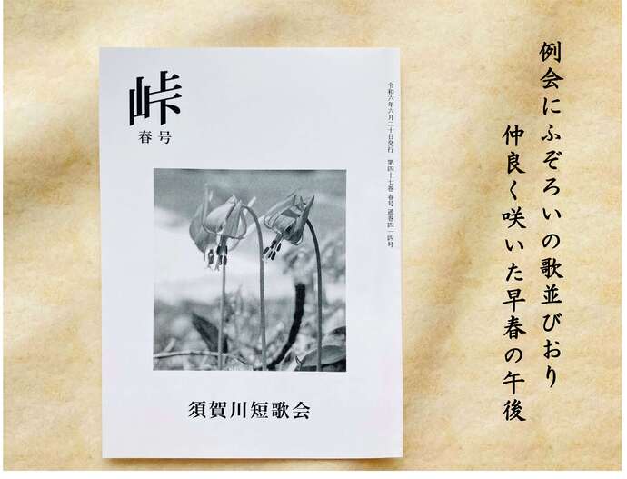 白い表紙に花の写真と題字が配された冊子が和紙風の背景に置かれ右側に短歌が添えられた写真