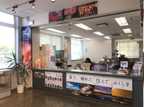 複数のポスターなどが貼られたカウンターの後ろに事務机が配置された、1階観光案内所の写真