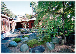 大きな石や低い植栽が配置された趣のある日本庭園の写真