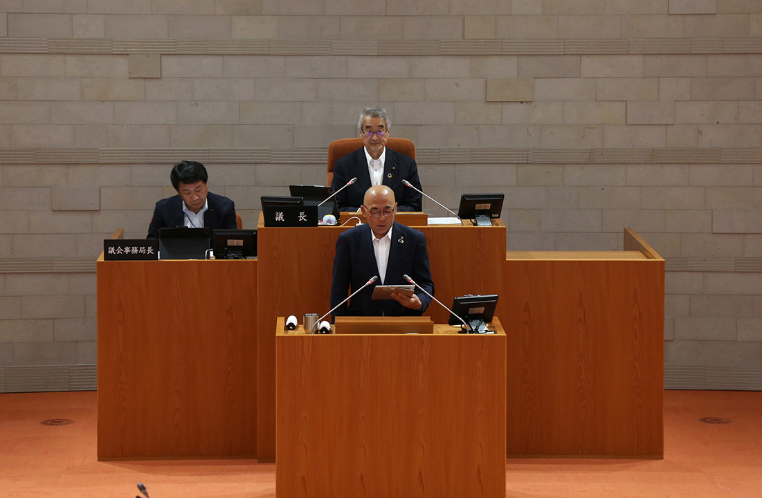 令和8年6月市議会定例会が開会し、議場で挨拶する大寺市長（前列中央）