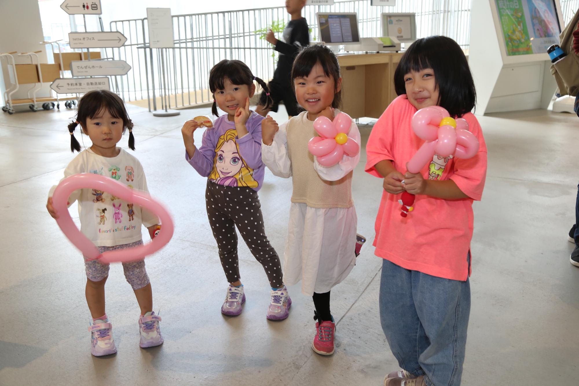 4人の女の子が風船を持って笑っている写真