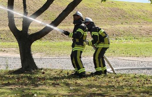 河川敷にて男性2人が消火活動を行っている写真