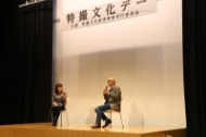 「特撮文化デー」と書かれた看板が掲げられた広いステージ上で、椅子に座った男女二人の登壇者がマイクを手に持ちながら対談をしている写真