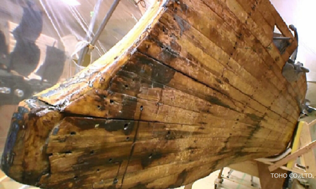 長年使い込まれたような質感を持つ巨大な「戦艦三笠」のミニチュアの塗装をはがし塗装されない状態で展示された船の一部分の写真