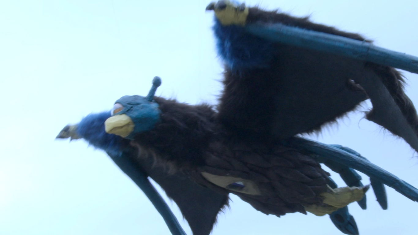 怪獣フェザーロンが羽ばたいて空を飛んでいる様子