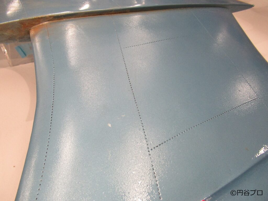 完成した大型戦闘機模型「スカイホエール」の機体表面を至近距離から撮影しており、グレーの下地段階で刻まれた精密なリベット跡が塗装後も規則正しい点線で再現されている機体写真