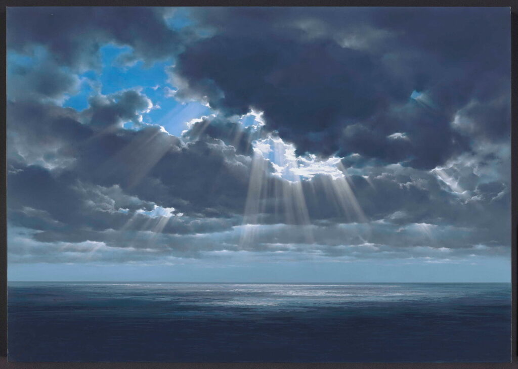 厚い雲の隙間から幾筋もの鮮烈な光が海面へと降り注ぐ「天使の梯子」が描かれており、静かな紺色の海とドラマチックな空のコントラストが、特撮映画の背景画ならではの神々しく幻想的な情景を表現している背景画の写真