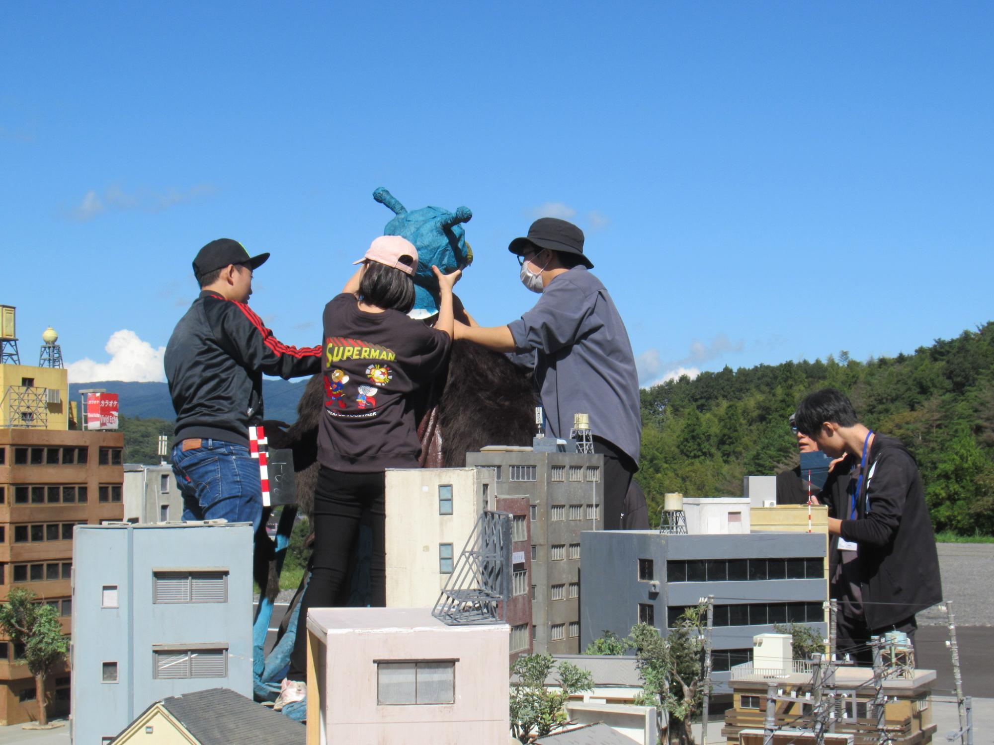 すかがわ特撮塾の活動で塾生たちがと屋外で特撮撮影を行う様子