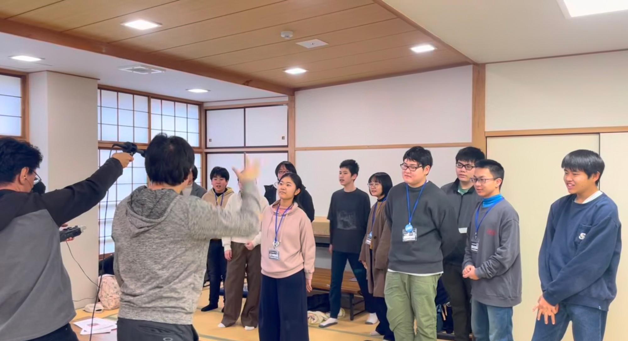 和室で塾生たちが講師の指揮に合わせてタイミングを合わせて声を録音している様子