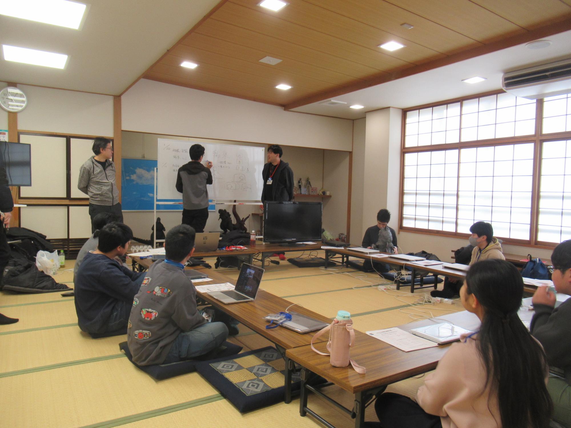 和室で講師の説明を聞いている塾生たちの様子